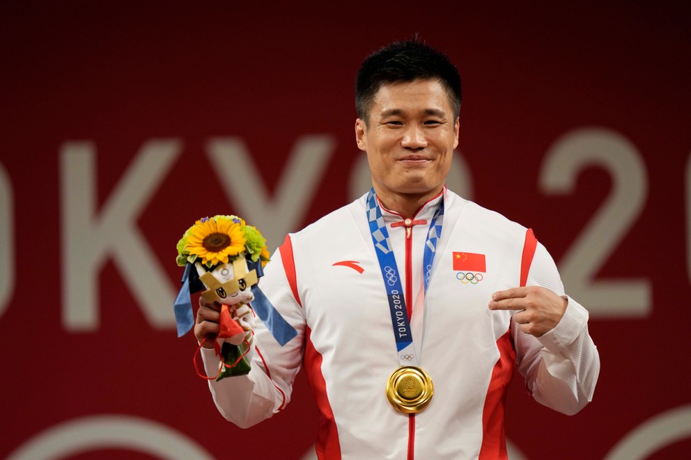 Čínsky vzpierač Liou Siao-ťün so zlatou olympijskou medailou. 