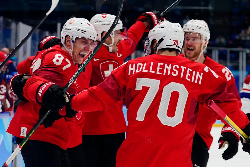 Švajčiarsky hokejista Killian Mottet (vľavo) sa teší so spoluhráčmi po strelení gólu v kvalifikačnom zápase o štvrťfinále Česko - Švajčiarsko na ZOH 2022 v Pekingu.