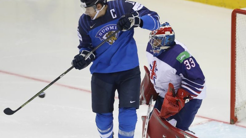 Fínsky kapitán Marko Antilla tečuje puk pred britkým brankárom Benom Bownsom v zápase Fínsko - Veľká Británia na MS 2019 v hokeji.