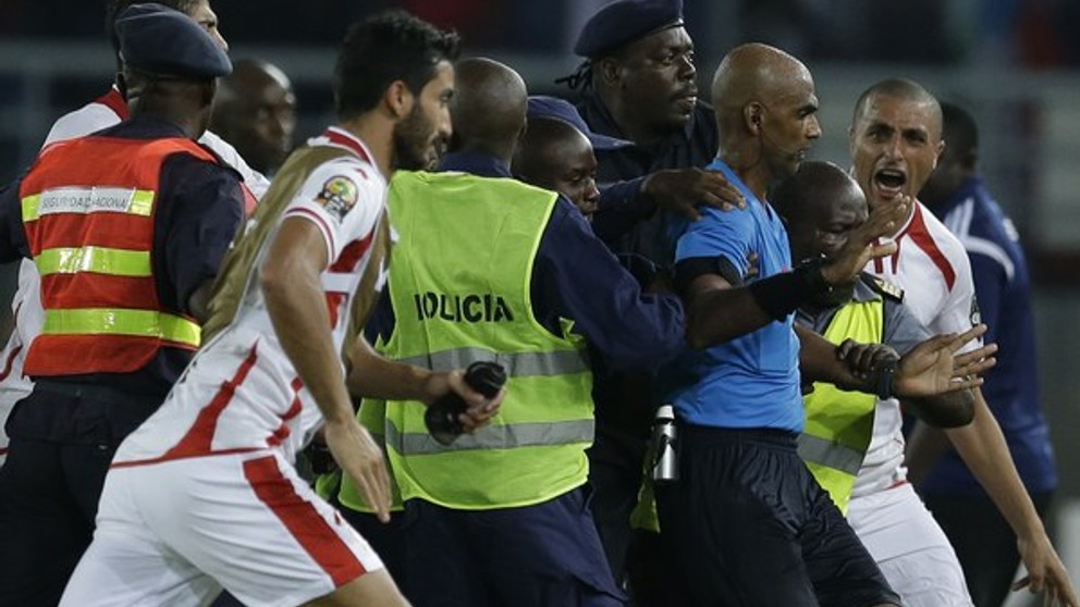 Rozhodcu Rajindraparsada Seechurna chráni pred hráčmi Tuniska ochranka.